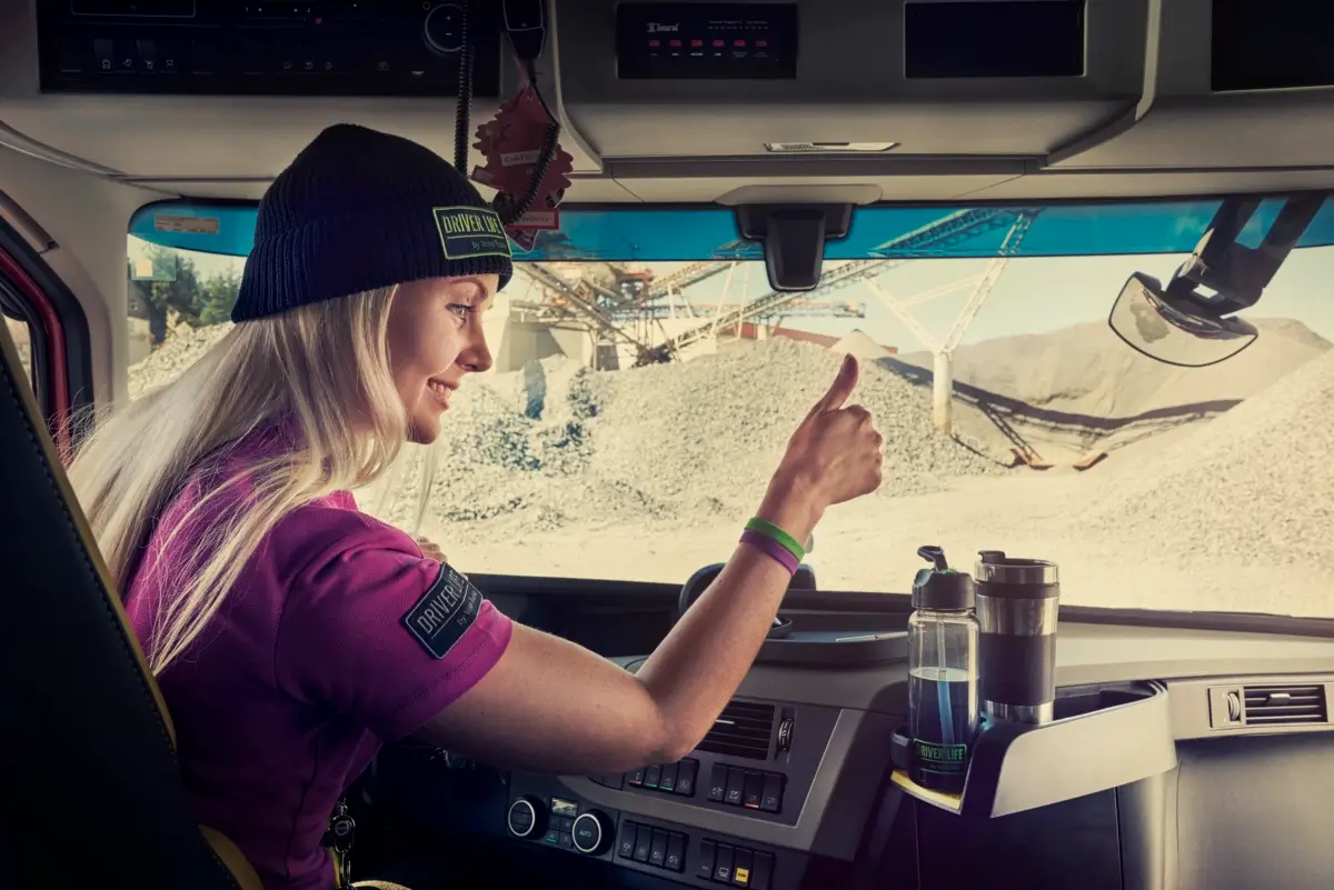 Męska dłoń obsługuje panel dotykowy w kabinie kierowcy pojazdu ciężarowego