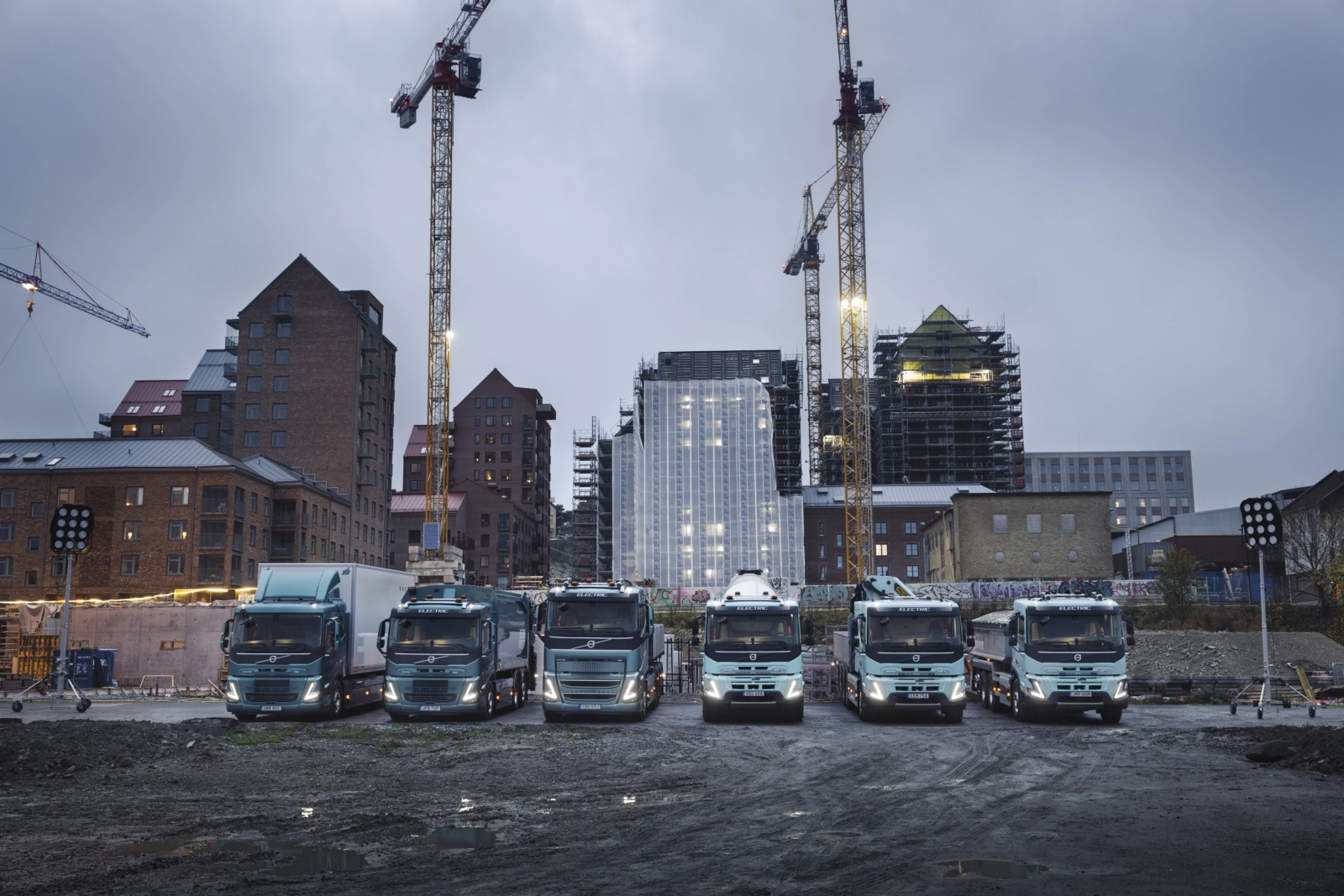 Elektryczne pojazdy ciężarowe Volvo stojące na placu budowy w szeregu