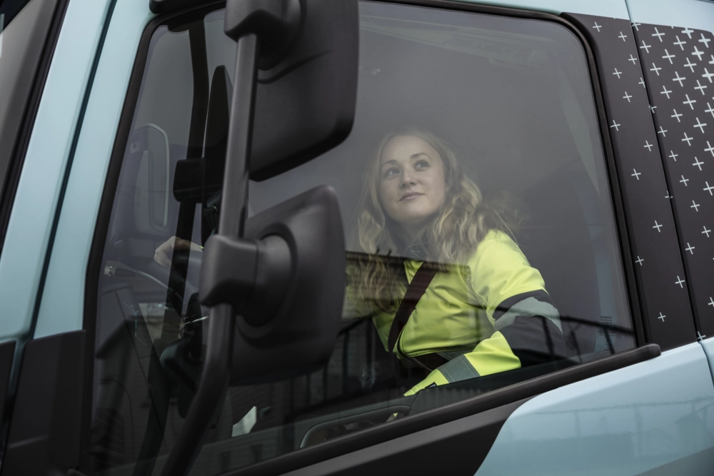 Kobieta siedząca na fotelu kierowcy w pojeździe ciężarowym ustawia tachograf